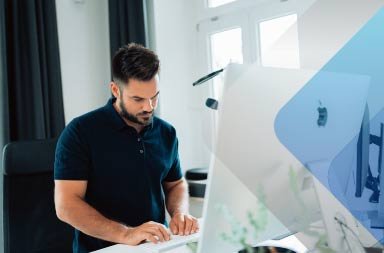 Hombre frente a una computadora Apple para ilustrar un artículo sobre la contratación de talento global. Foto de Malte Helmhold en Unsplash.