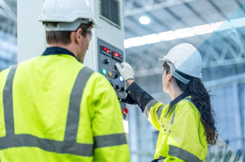 Dois funcionários trabalhando em equipamentos para fábricas de montagem de eletrônicos.
