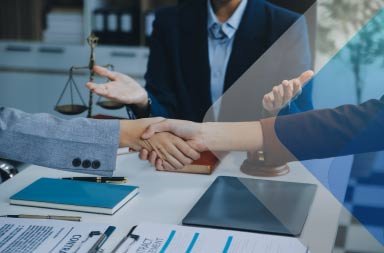 Dos personas dándose la mano y firmando contratos, ilustrando un acuerdo, para ilustrar la comparación EOR vs PEO