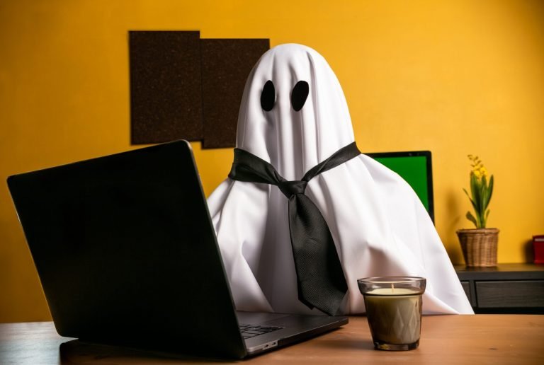 pessoa vestida como um fantasma trabalhando em um laptop